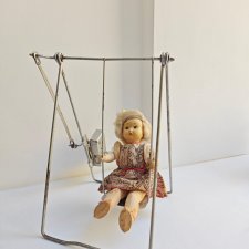 Куколка на механических качелях