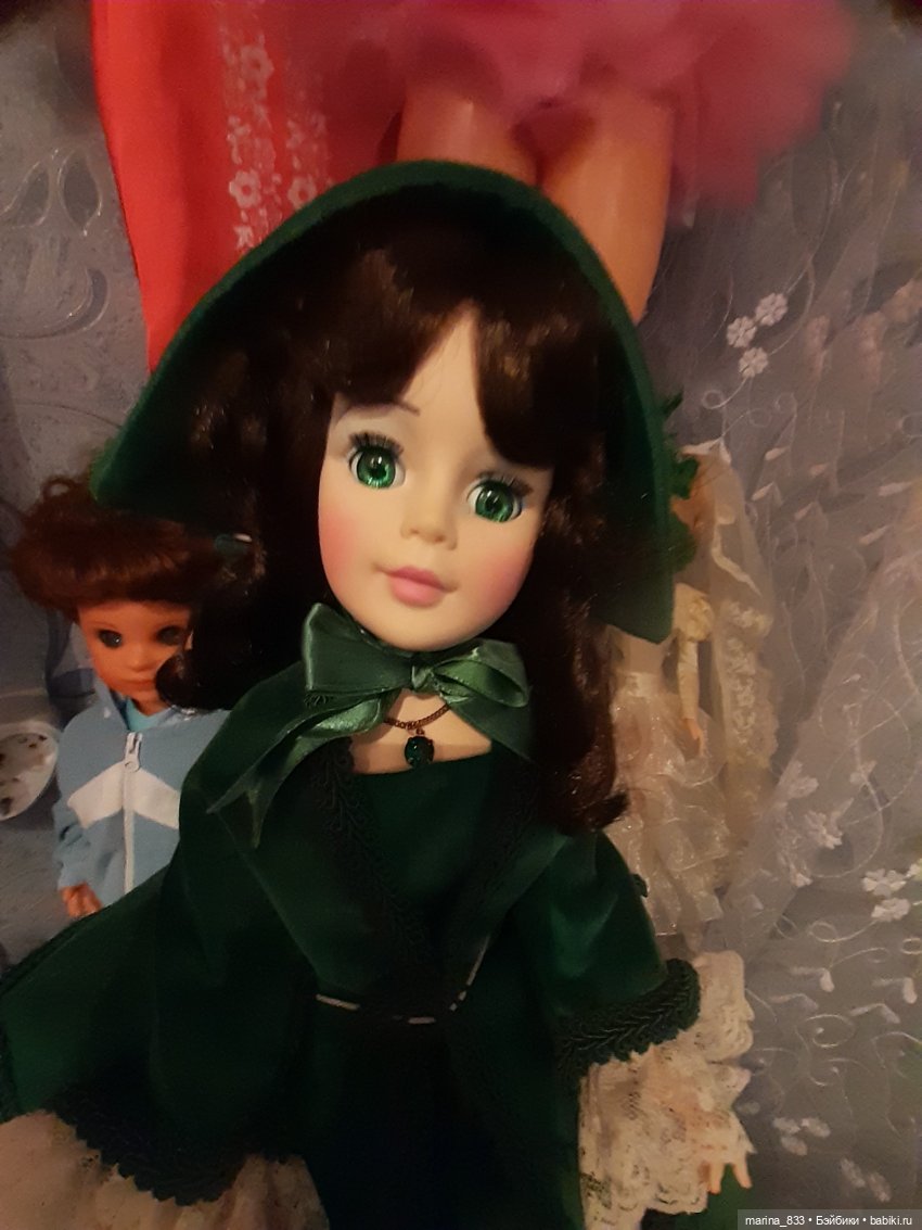 На шейке цепочка с изумрудом