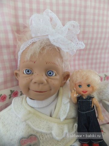 Малыш в белом с куклой и бантом