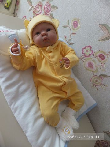 На комоде, в жёлтом, смотрит прямо