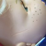 Глубокие царапины и темные пятна на кукле из твердого винила