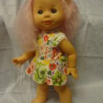 Маленькая куколка с розовыми волосами.
