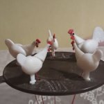 Курочки клюют зерно на кормушке.