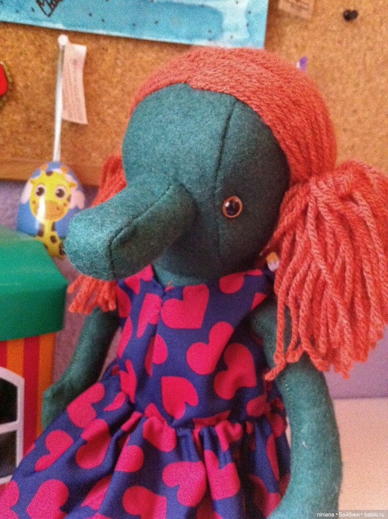 Это Энни Крок, она сделана из фетра, поэтому летом ей очень жарко. Любит сердечки, рукоделие и шерсть.