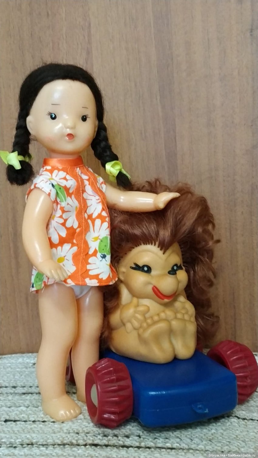 Юля изучает игрушки с благотворительной полочки