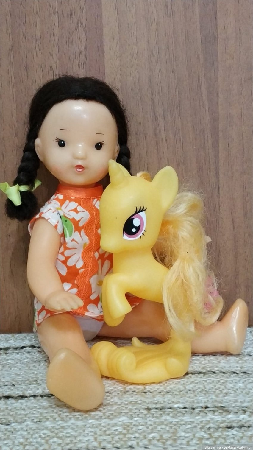 Юля изучает игрушки с благотворительной полочки