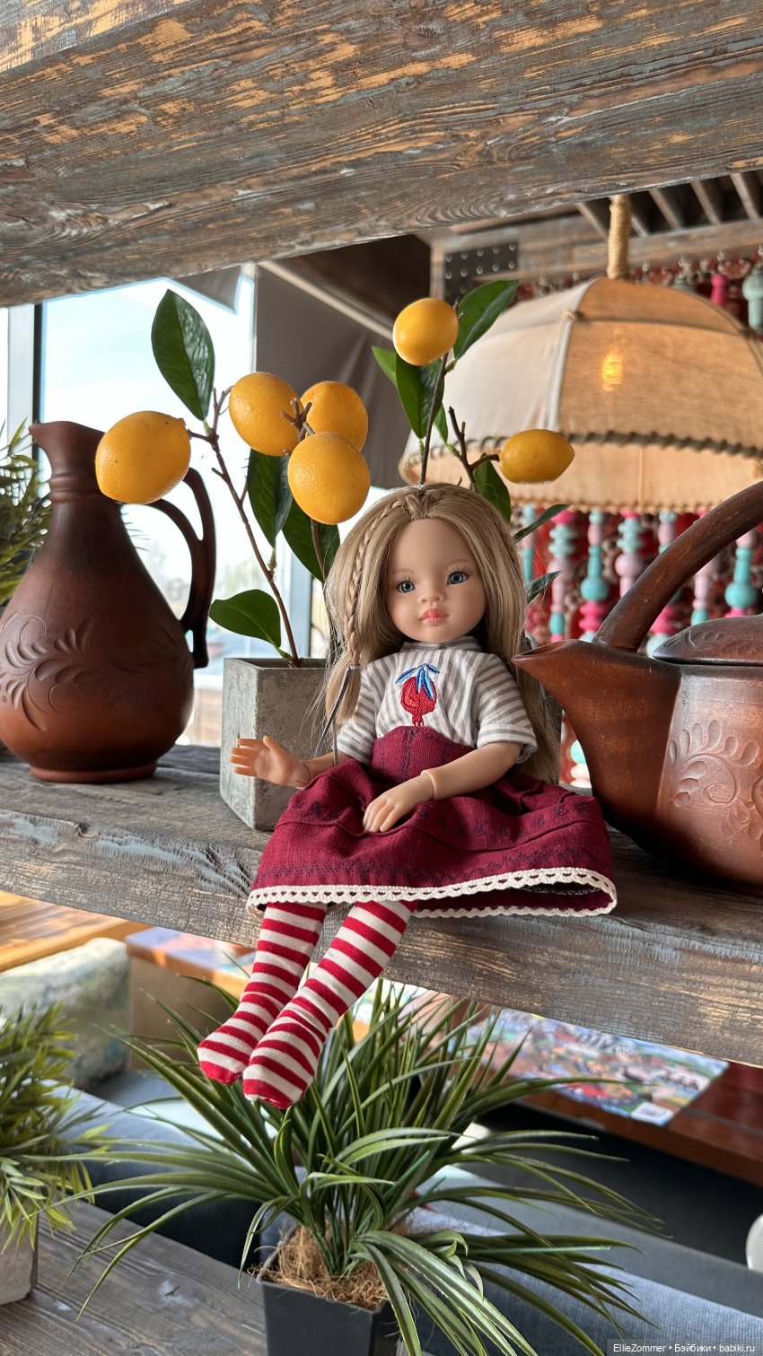 Девочка отдыхает под лимонным деревцем. Сидит в юбке изо льна, спереди выглядит как корсетик