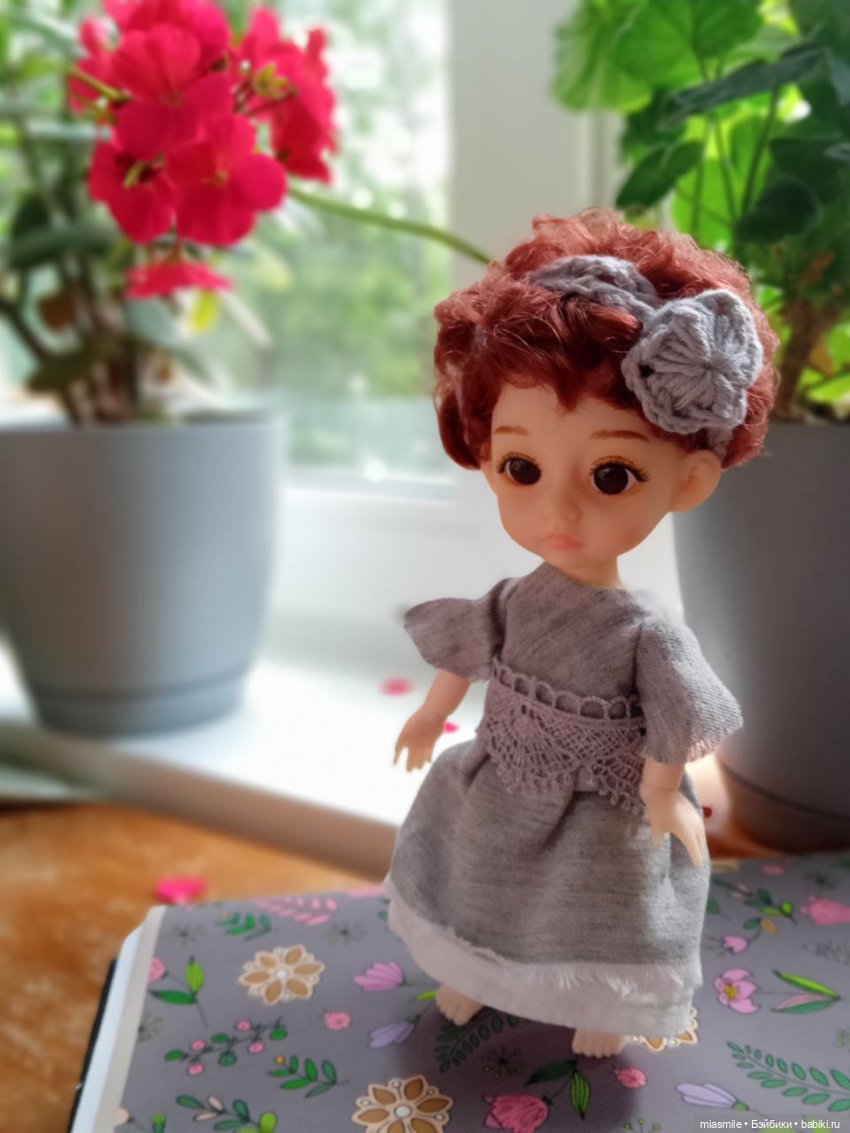 Эрика на фоне горшков с геранью