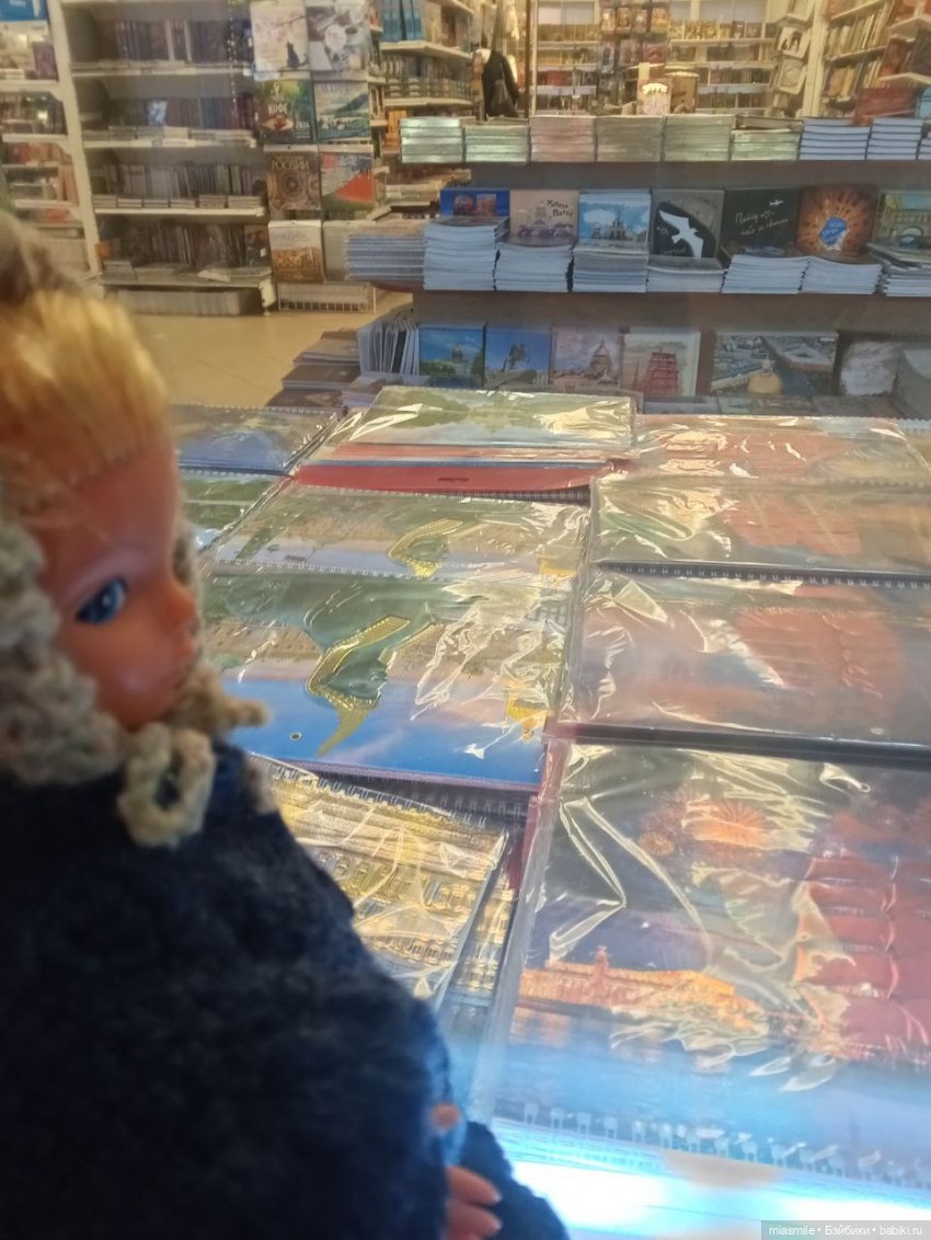 Кукла ГДР Элис изучает витрину с календарями и книгами Кукла ГДР Элис изучает витрину с календарями и книгами