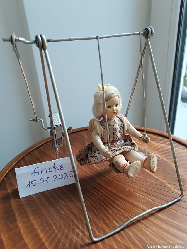 Куколка на механических качелях